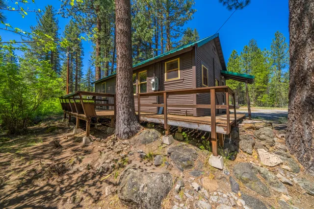 a backyard of a house with wooden fence and large trees