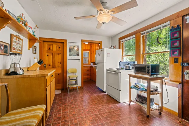 a view of a kitchen with fridge and workspace