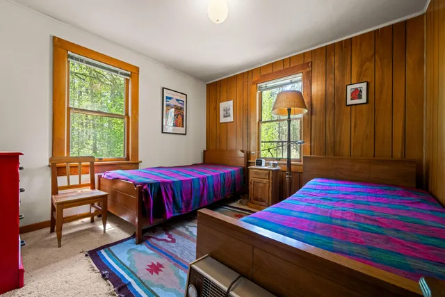 a bedroom with two beds and a window