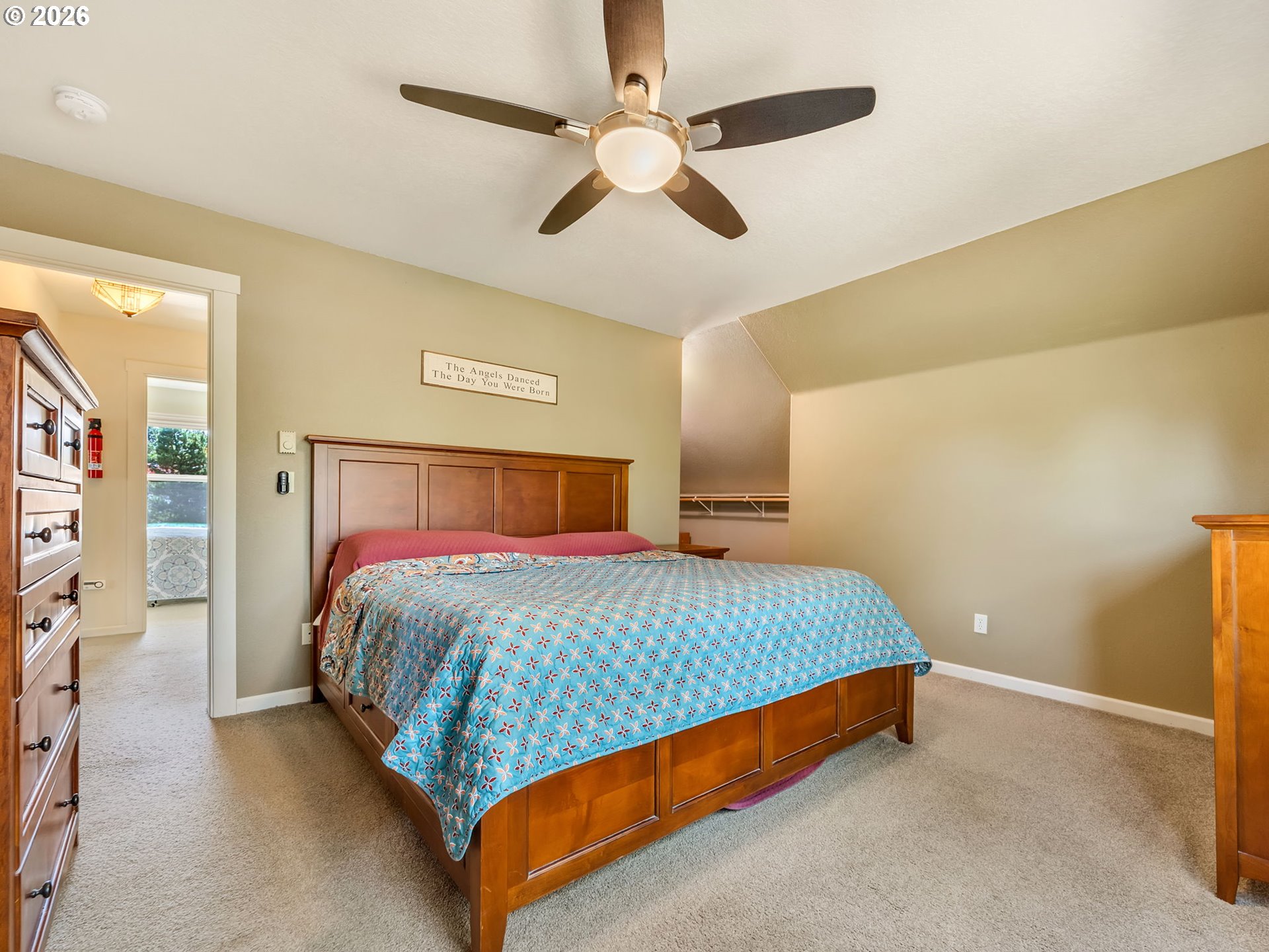 1077 Southwest Ridge Road Warrenton, OR 97146 - Photo 30 of 46 a bed sitting in a spacious bedroom next to a window and a chandelier