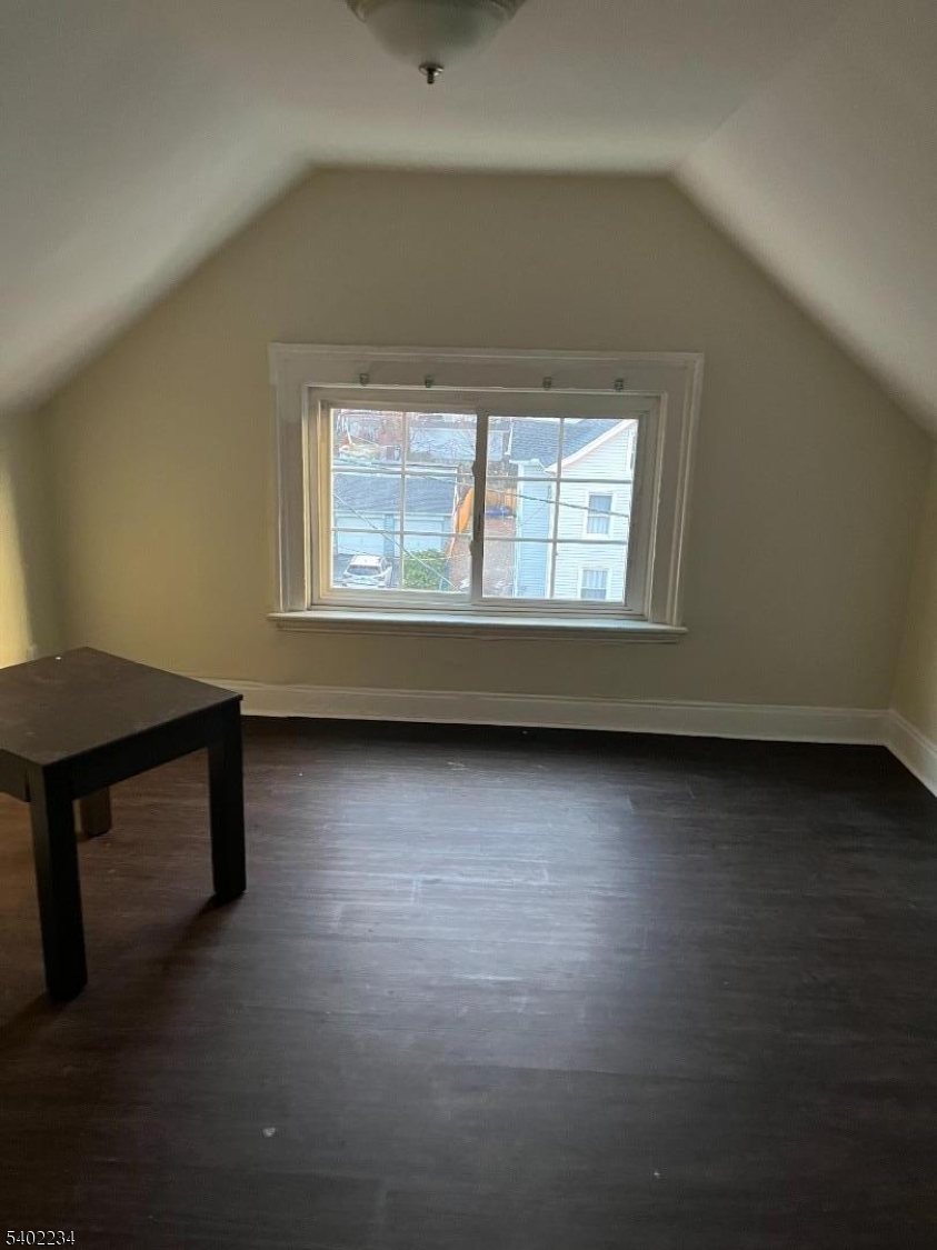 49 Orchard Street Elizabeth, NJ 07208 - Photo 3 of 6 an empty room with wooden floor and windows