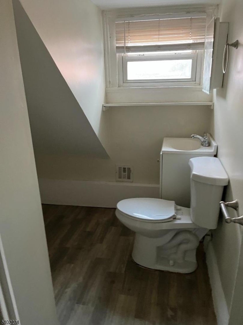 49 Orchard Street Elizabeth, NJ 07208 - Photo 5 of 6 a white toilet sitting next to a window