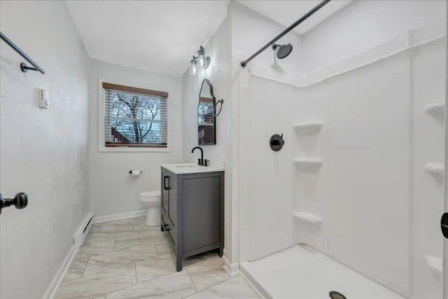 a bathroom with a sink a toilet and shower