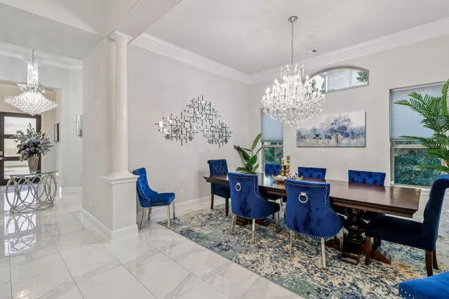 a living room with furniture a chandelier and kitchen view