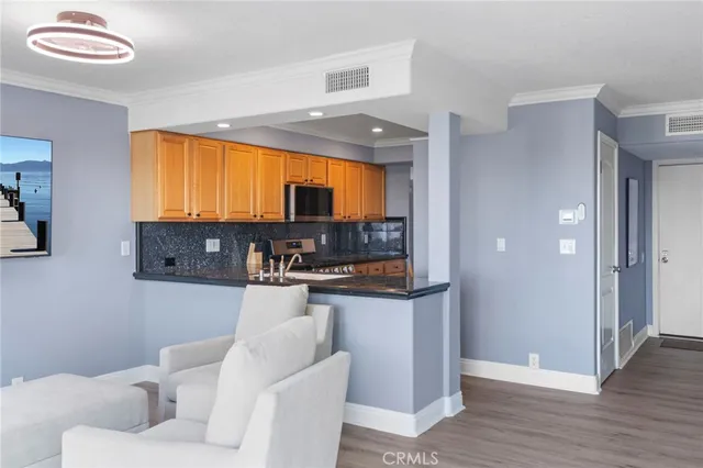 a living room with stainless steel appliances furniture and a flat screen tv