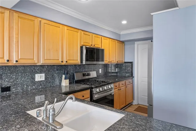 a kitchen with stainless steel appliances granite countertop a sink stove and microwave