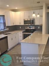 a kitchen with kitchen island granite countertop a sink and a stove