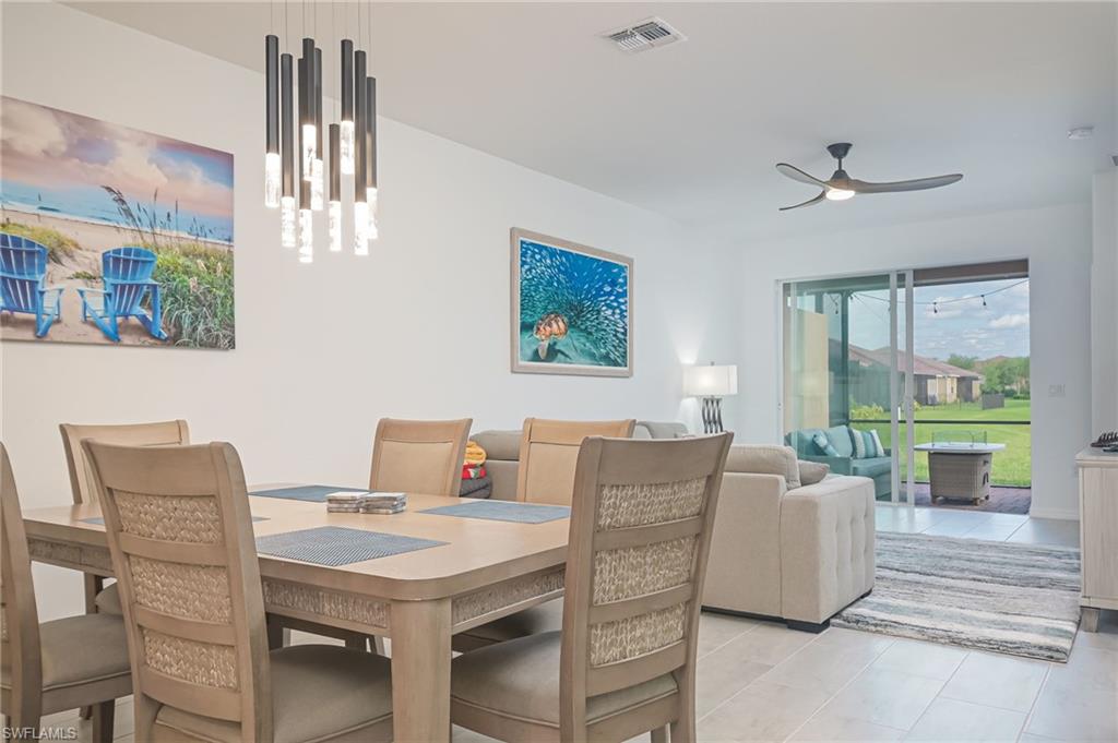 2073 Tamarron Lane Naples, FL 34120 - Photo 2 of 22 a view of a dining room with furniture a chandelier and wooden floor