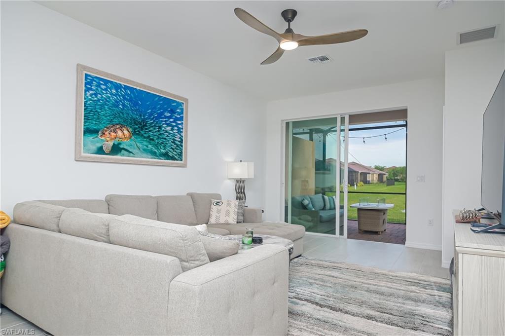 2073 Tamarron Lane Naples, FL 34120 - Photo 3 of 22 a living room with furniture and a flat screen tv