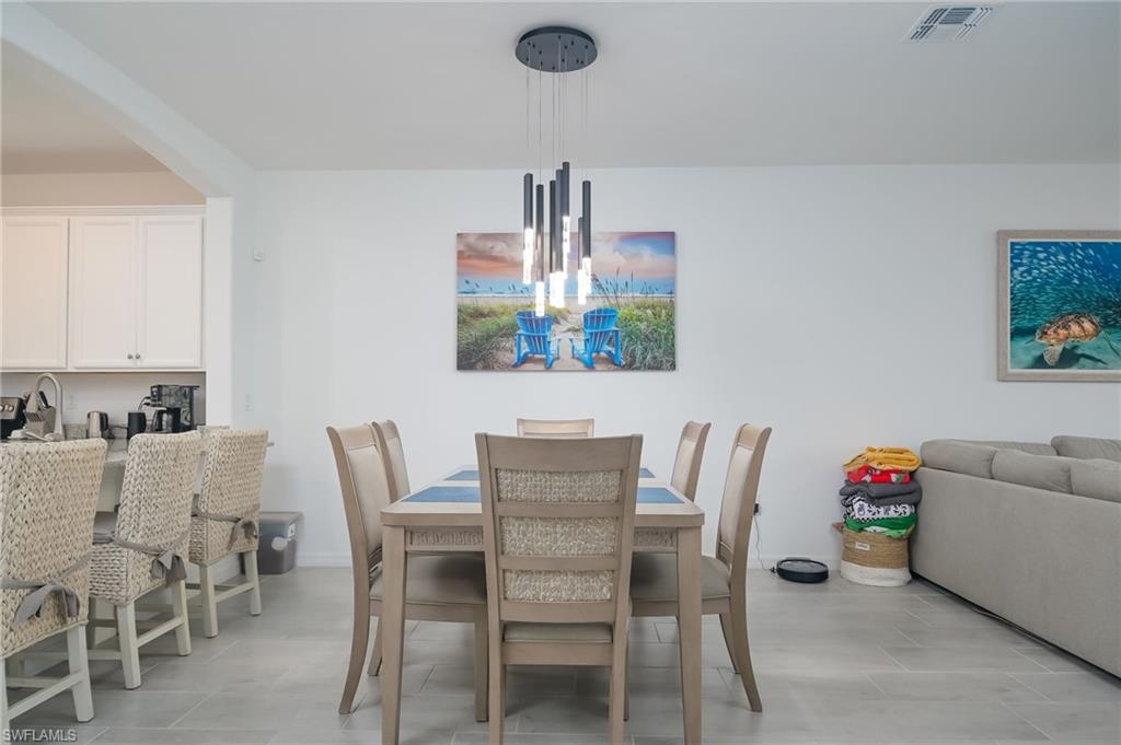 2073 Tamarron Lane Naples, FL 34120 - Photo 5 of 22 a dining room with furniture and a chandelier