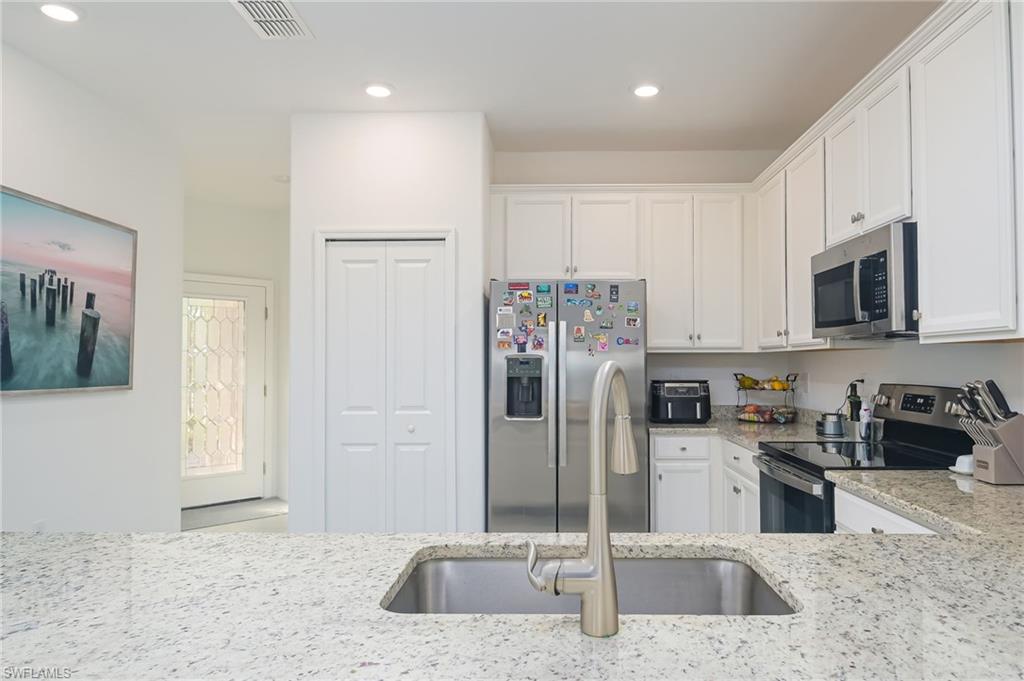 2073 Tamarron Lane Naples, FL 34120 - Photo 7 of 22 a kitchen with stainless steel appliances granite countertop a refrigerator and a sink