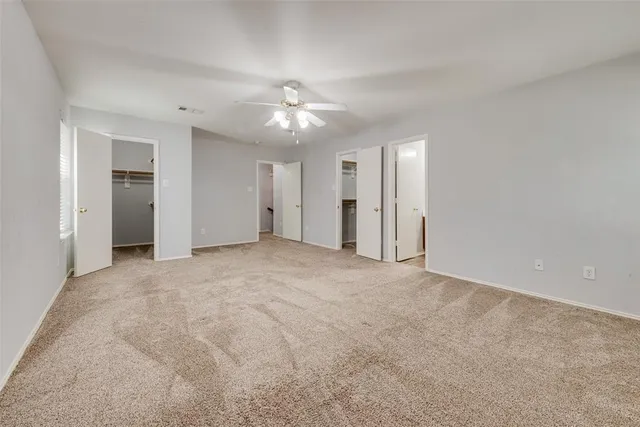a view of an empty room with a ceiling fan