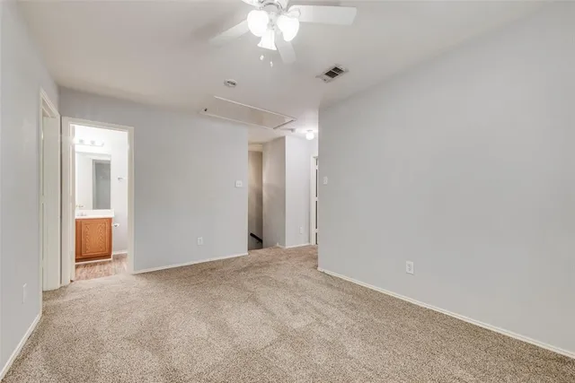 a view of an empty room with a chandelier fan