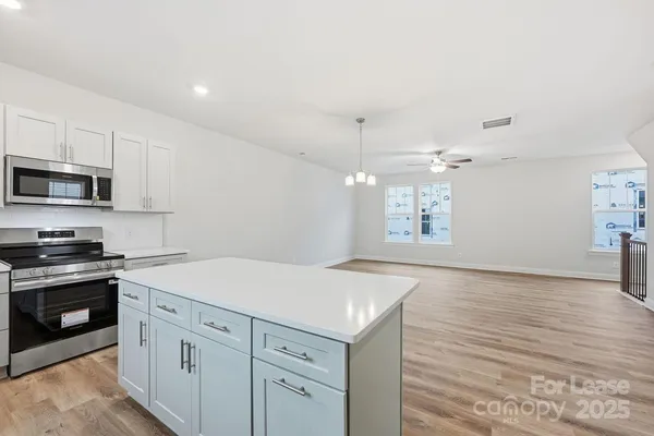 a kitchen with granite countertop white cabinets and white appliances