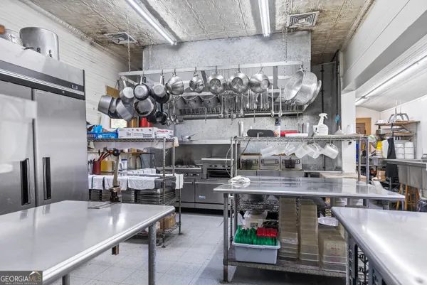 a room with stainless steel appliances kitchen island a table and chairs