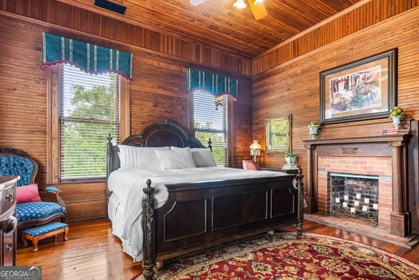 a bedroom with a bed and a fireplace next to a window