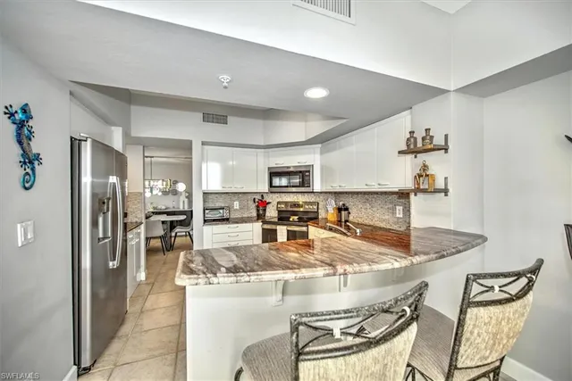 a kitchen with white cabinets and appliances