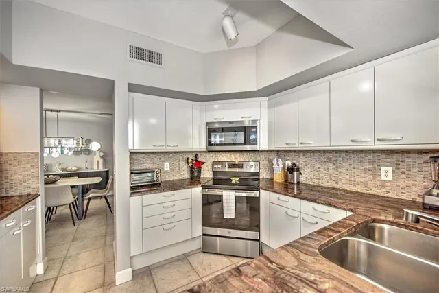 a kitchen with stainless steel appliances granite countertop a refrigerator and a counter space