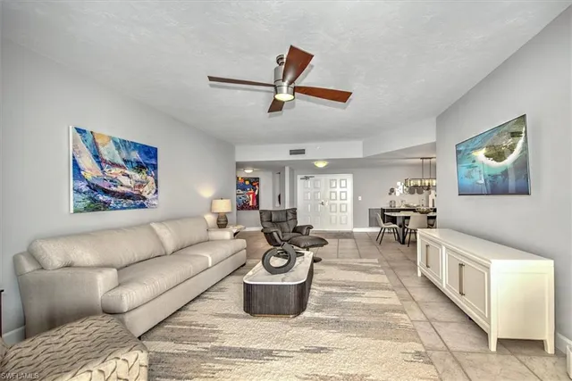 a living room with furniture kitchen view and a window