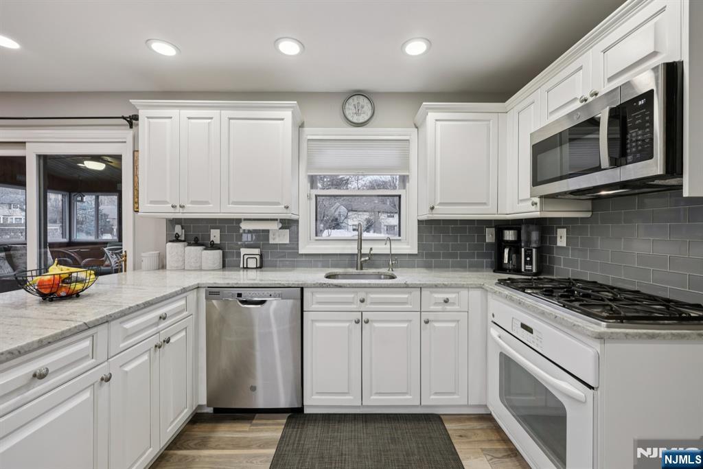 7 Welsh Court Wayne, NJ 07470 - Photo 13 of 40 a kitchen with stainless steel appliances granite countertop a stove a sink and a microwave