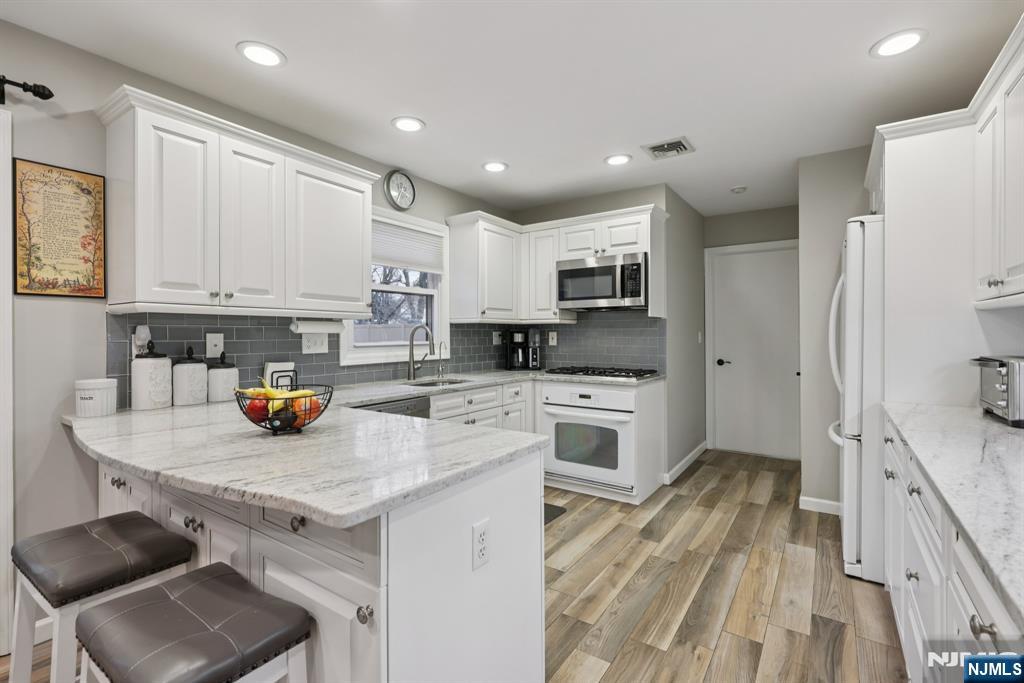 7 Welsh Court Wayne, NJ 07470 - Photo 15 of 40 a kitchen with a sink stove and refrigerator