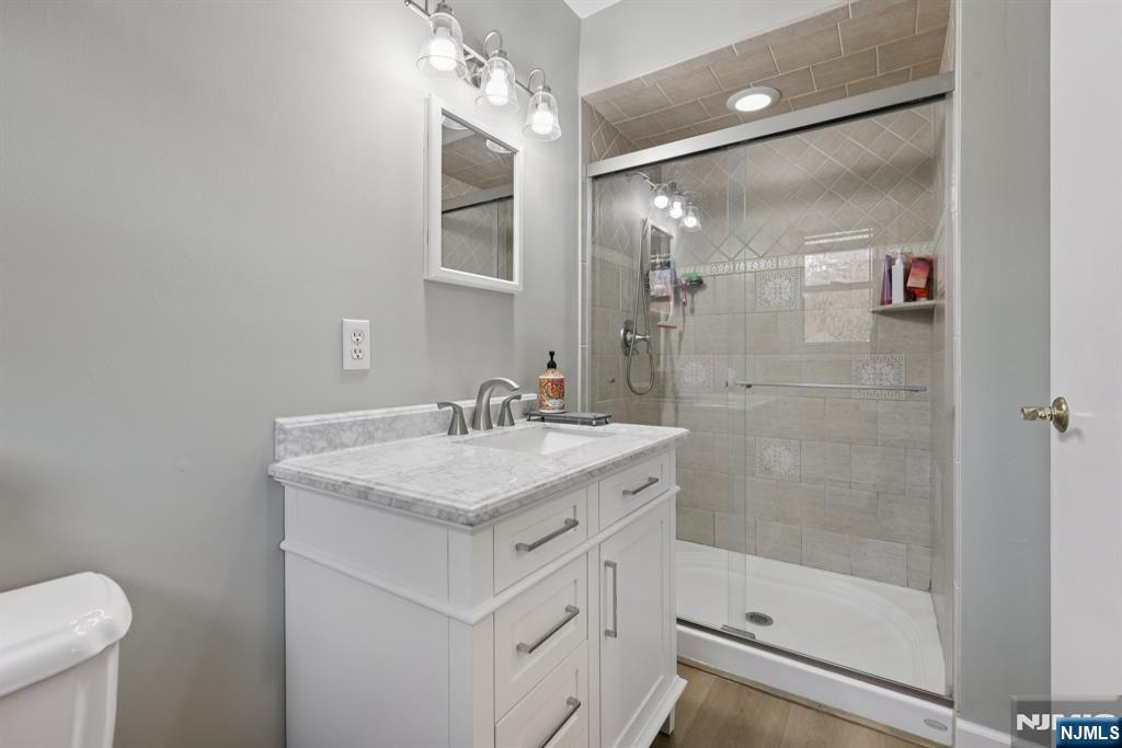 7 Welsh Court Wayne, NJ 07470 - Photo 23 of 40 a bathroom with a shower sink and mirror