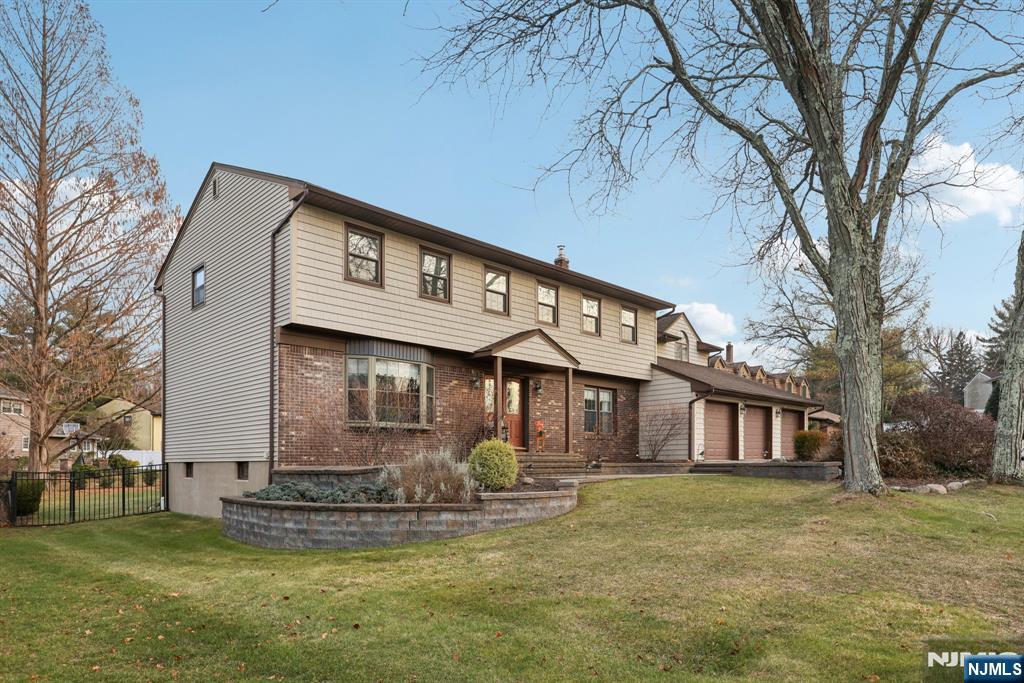 7 Welsh Court Wayne, NJ 07470 - Photo 3 of 40 a front view of a house with a garden and trees