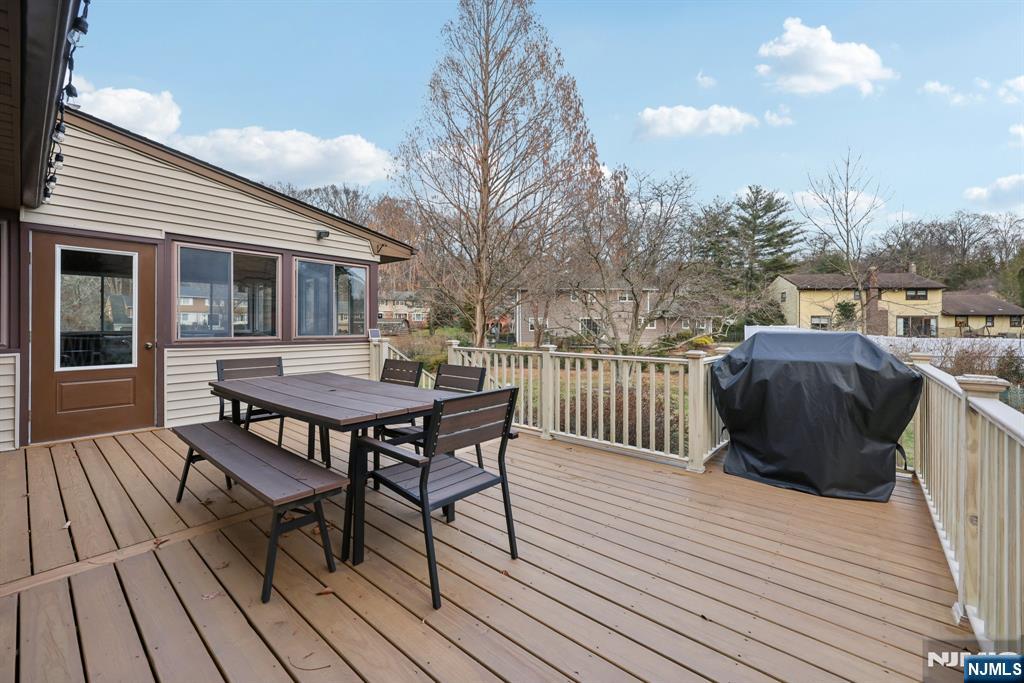 7 Welsh Court Wayne, NJ 07470 - Photo 31 of 40 a view of a roof deck with table and chairs with wooden floor and fence