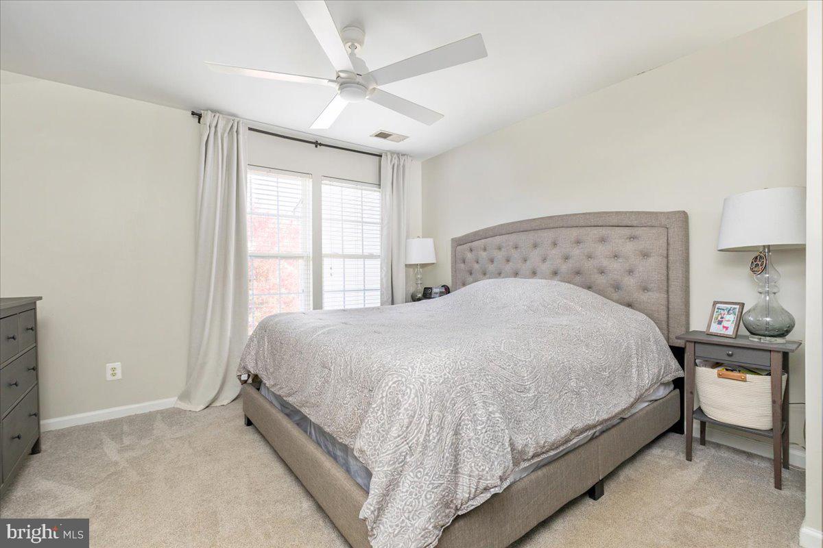 7235 Traphill Way Gainesville, VA 20155 - Photo 16 of 40 a large bed sitting in a bedroom next to a window and a chandelier