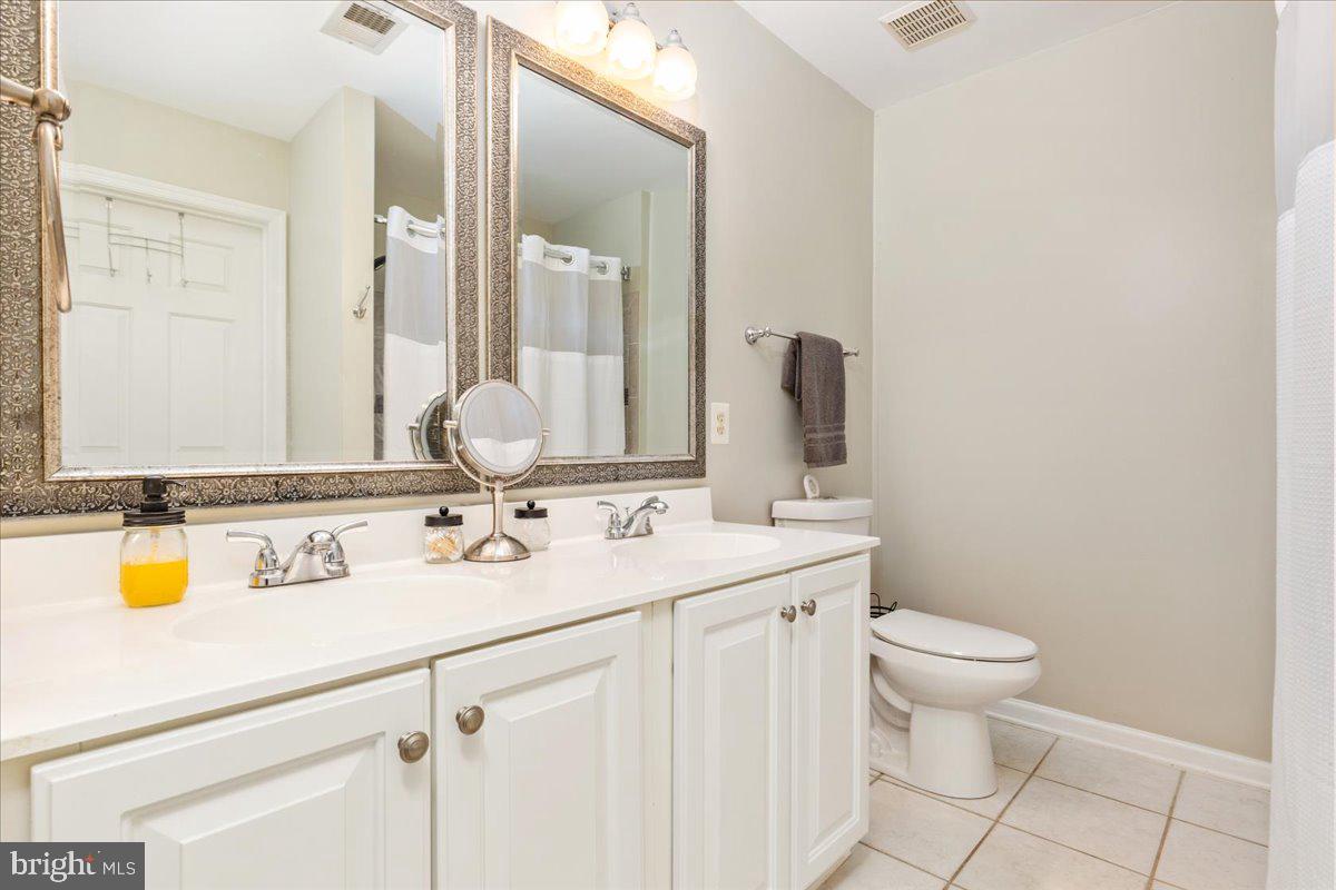 7235 Traphill Way Gainesville, VA 20155 - Photo 19 of 40 a bathroom with a granite countertop toilet sink and mirror