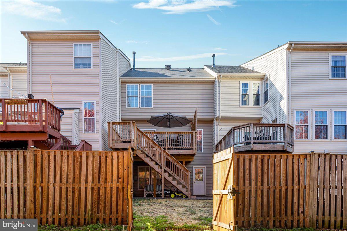 7235 Traphill Way Gainesville, VA 20155 - Photo 30 of 40 a view of a brick house with wooden fence