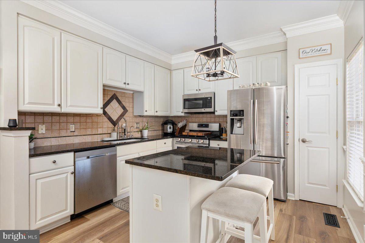 7235 Traphill Way Gainesville, VA 20155 - Photo 9 of 40 a kitchen with stainless steel appliances a refrigerator sink and cabinets
