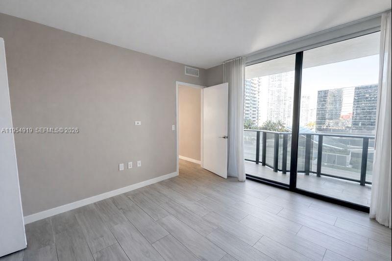 45 Southwest 9th Street, Unit 1208 Miami, FL 33130 - Photo 14 of 27 an empty room with wooden floor and door