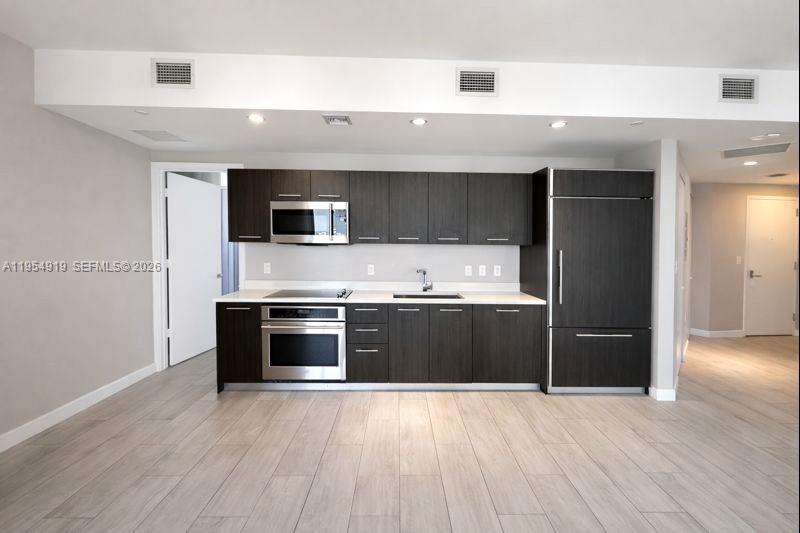 45 Southwest 9th Street, Unit 1208 Miami, FL 33130 - Photo 5 of 27 a kitchen with a refrigerator and a stove top oven