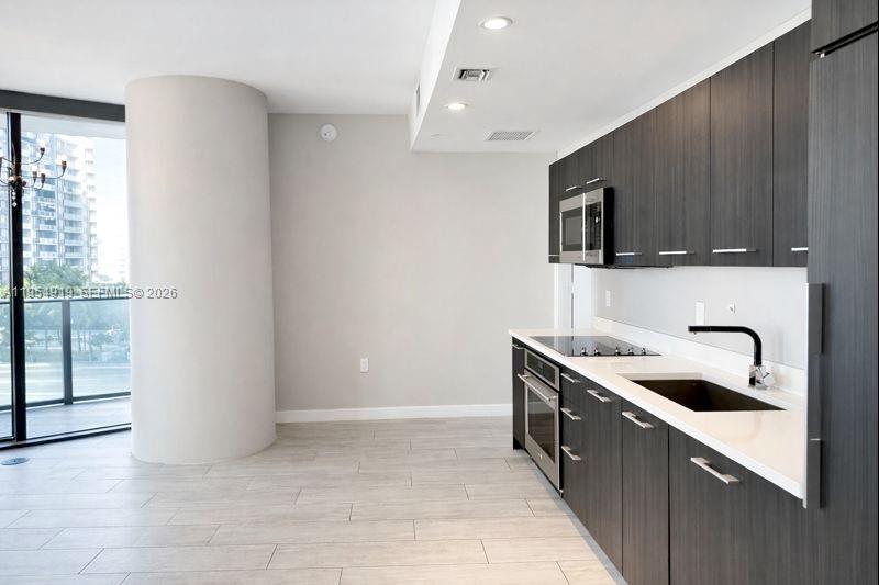 45 Southwest 9th Street, Unit 1208 Miami, FL 33130 - Photo 7 of 27 a kitchen with stainless steel appliances granite countertop a sink and a stove top oven