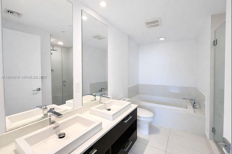 45 Southwest 9th Street, Unit 1208 Miami, FL 33130 - Photo 9 of 27 a bathroom with a tub sink toilet and mirror