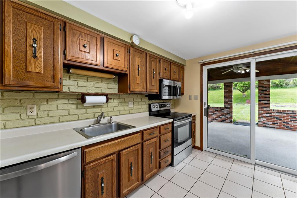 27 Dover Road Irwin, PA 15642 - Photo 11 of 43 a kitchen with stainless steel appliances granite countertop a sink and cabinets