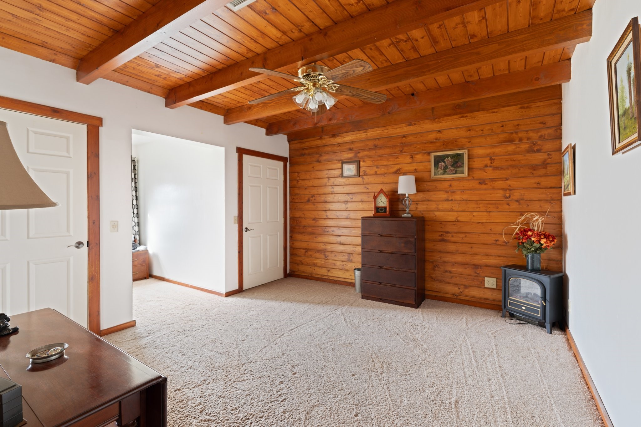 8226 Fm 2354 Beach Baytown, TX 77523 - Photo 22 of 39 Secondary bedrooms upstairs feature beamed ceilings, rich wood accents, and plush carpet underfoot—offering cozy comfort and rustic charm.