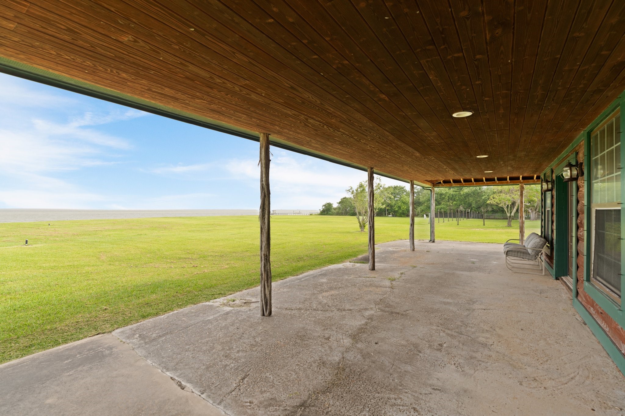 8226 Fm 2354 Beach Baytown, TX 77523 - Photo 35 of 39 The guest home’s wrap-around porch, supported by cypress log posts, is ideal for enjoying bay breezes.