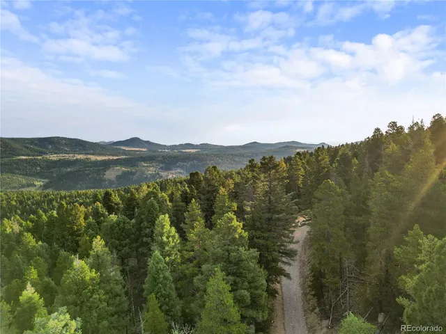 a view of a mountain range with lush green forest
