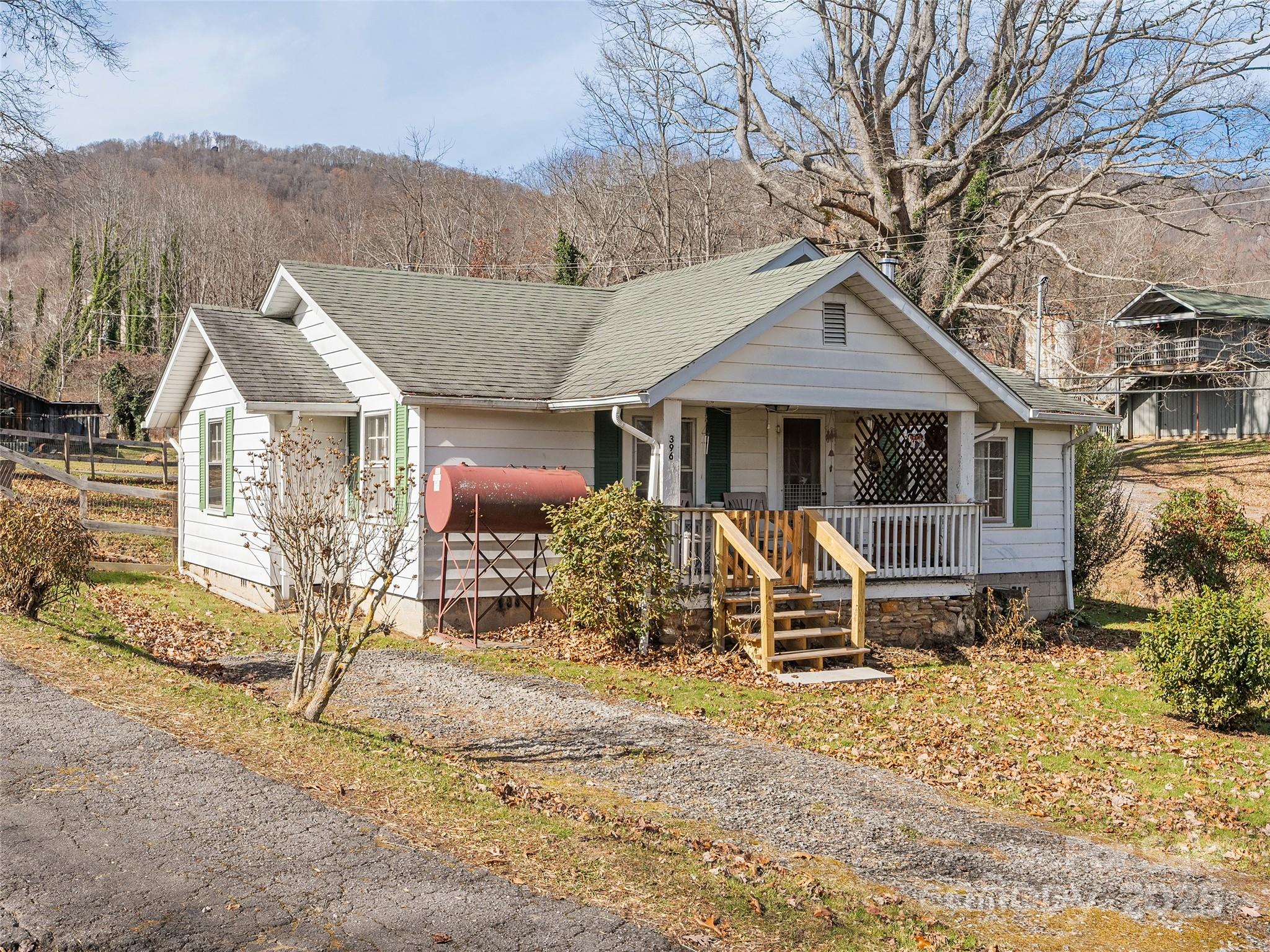 396 Will Hyatt Road Waynesville, NC 28786 - Photo 1 of 23 a wooden bench sitting in front of a house