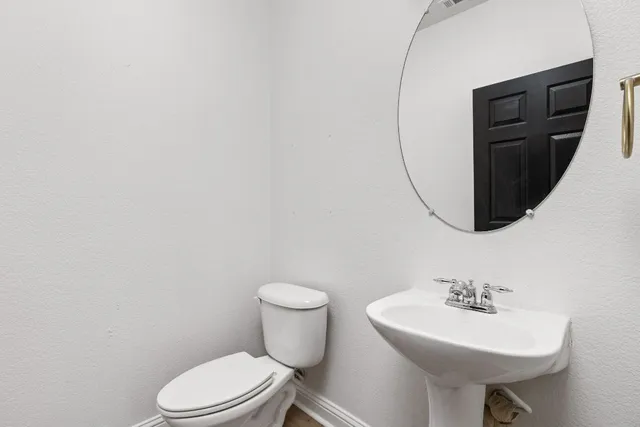 a bathroom with a sink toilet and a mirror