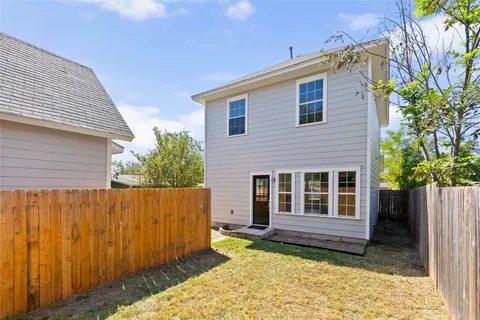 a view of a house with a large window and wooden fence