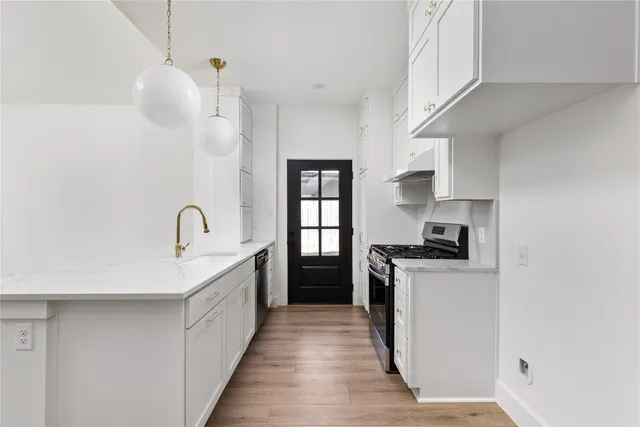 a kitchen with stainless steel appliances granite countertop a stove a sink and a refrigerator
