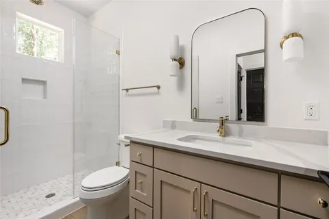 a bathroom with a sink a toilet and shower