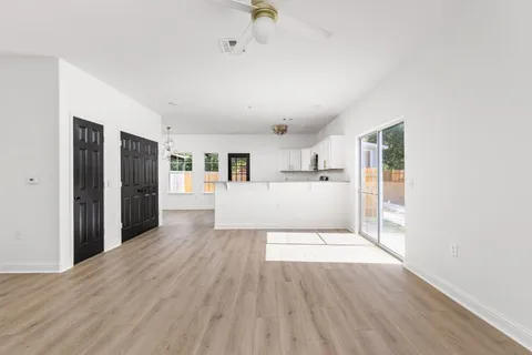 a view of a kitchen with wooden floor and electronic appliances