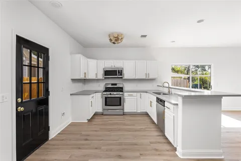 a kitchen with stainless steel appliances a stove top oven and a refrigerator