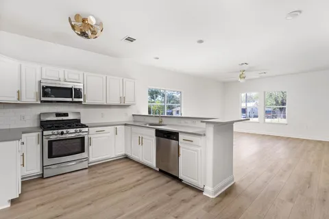 a kitchen with kitchen island granite countertop a sink cabinets and wooden floor