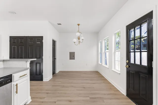 a view of a kitchen with an entryway and wooden floor