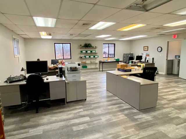 a living room with couches and kitchen view with wooden floor
